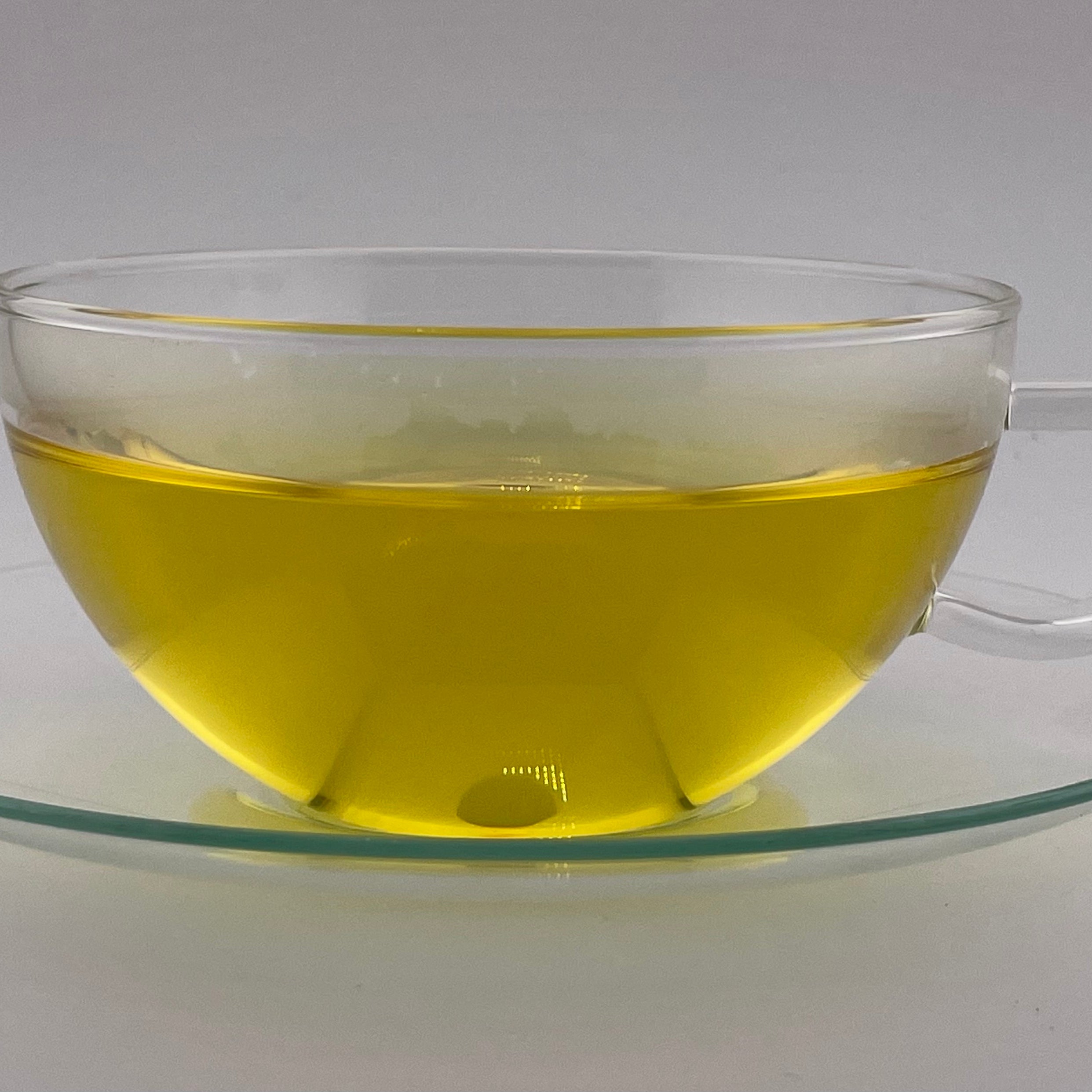 yellow liquor in clear tea cup on white background