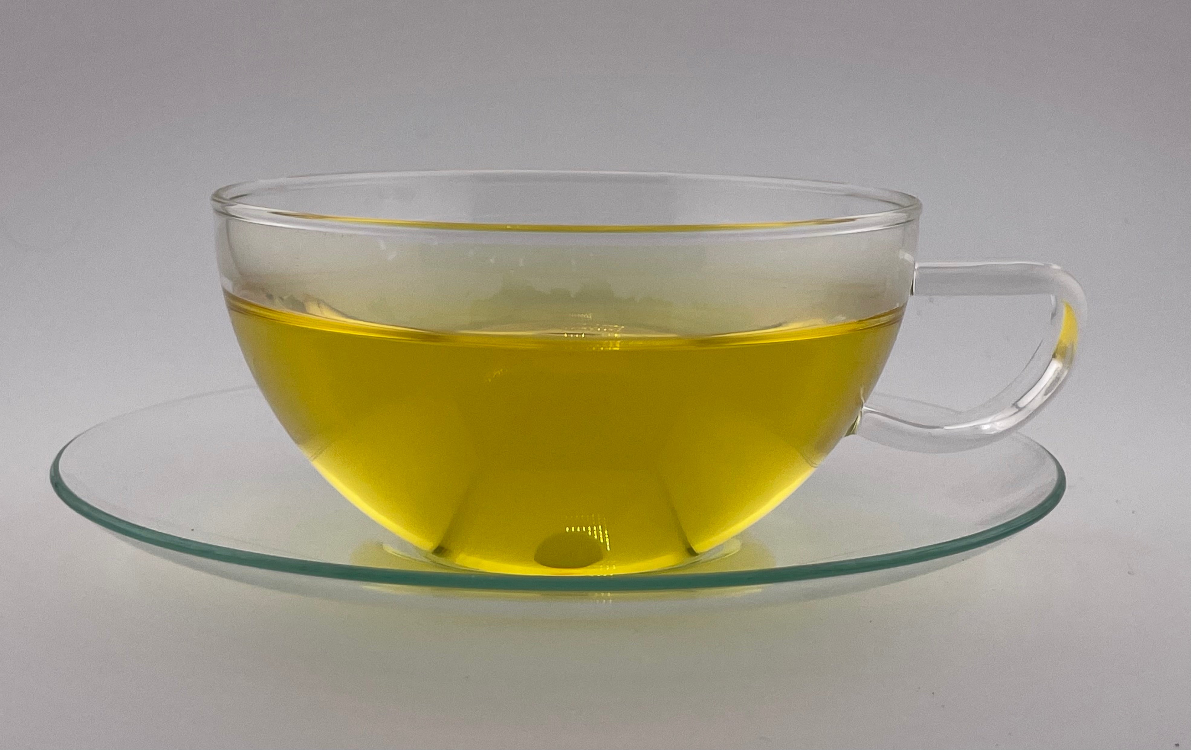 yellow liquor in clear tea cup on white background