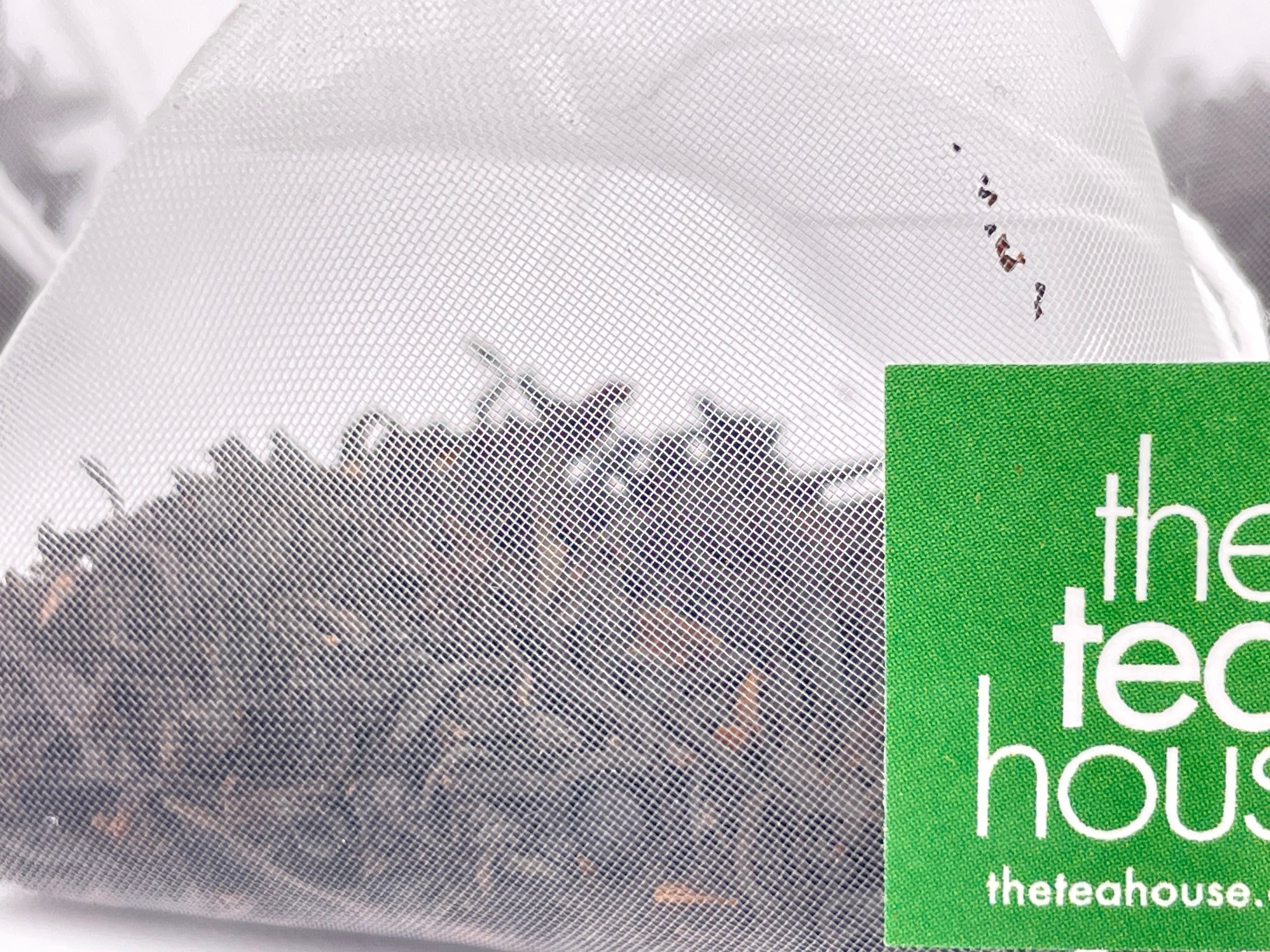 teabag containing loose leaf tea with green and white tag