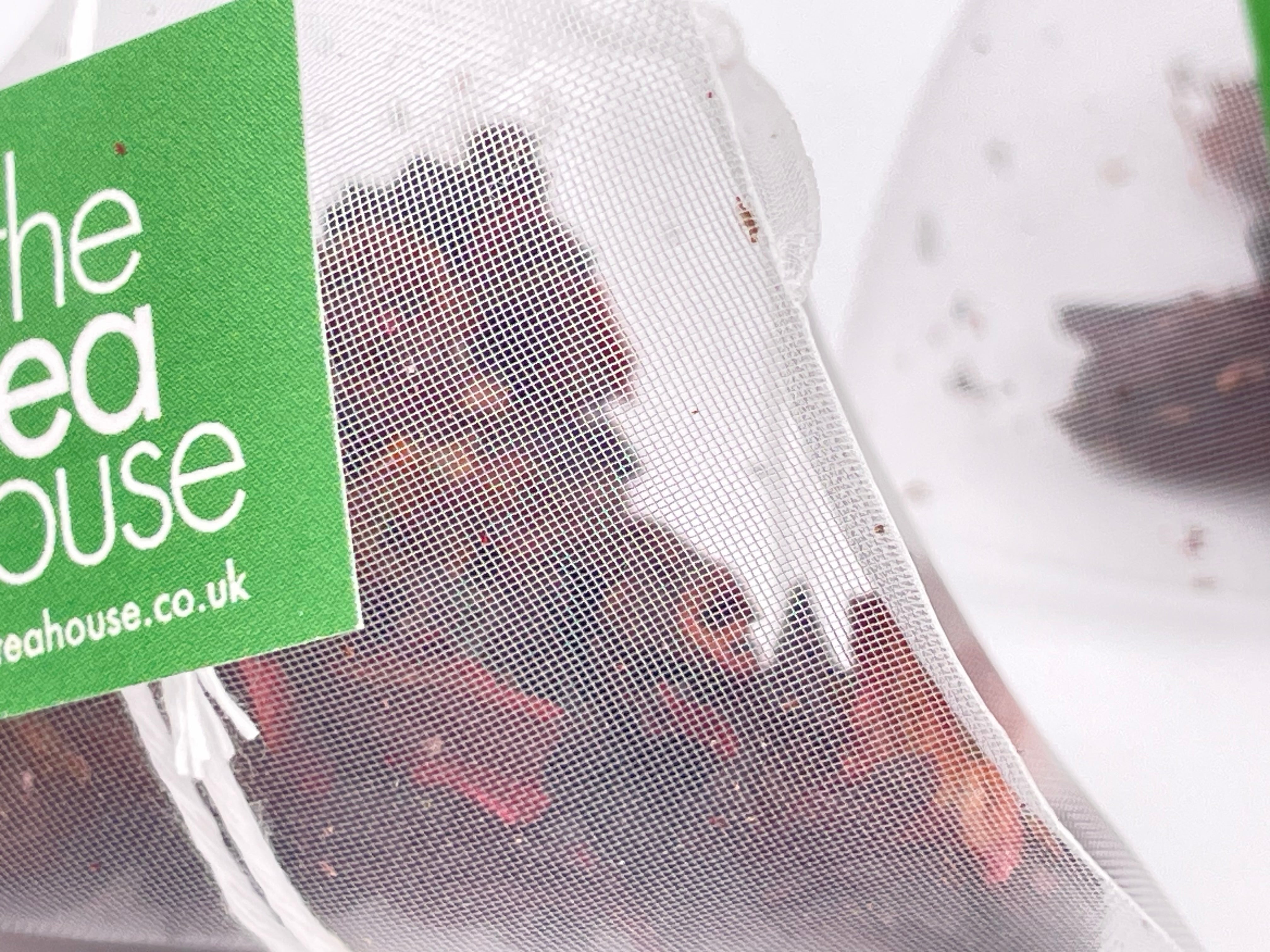 Tea bag with a green label reading 'The Tea House' on a white background.