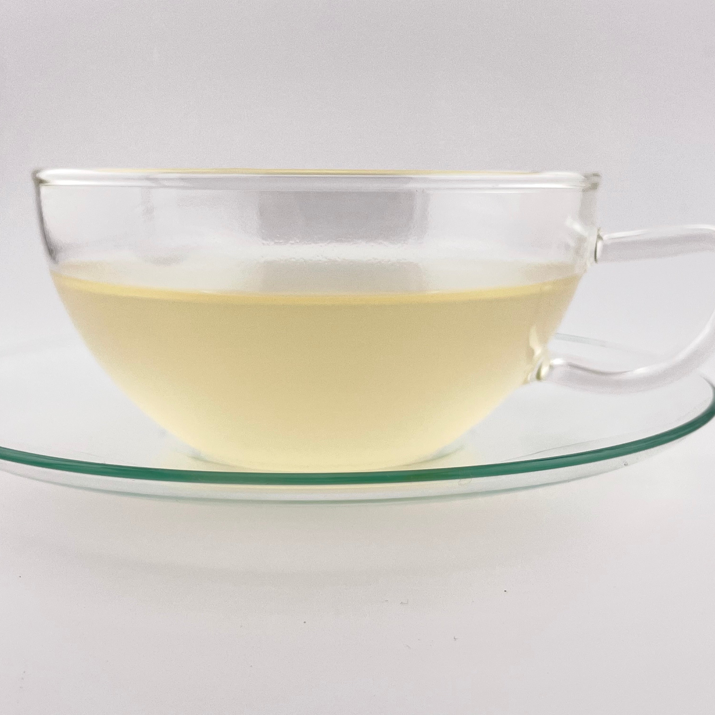 Light yellow liquor in a tea cup with white background