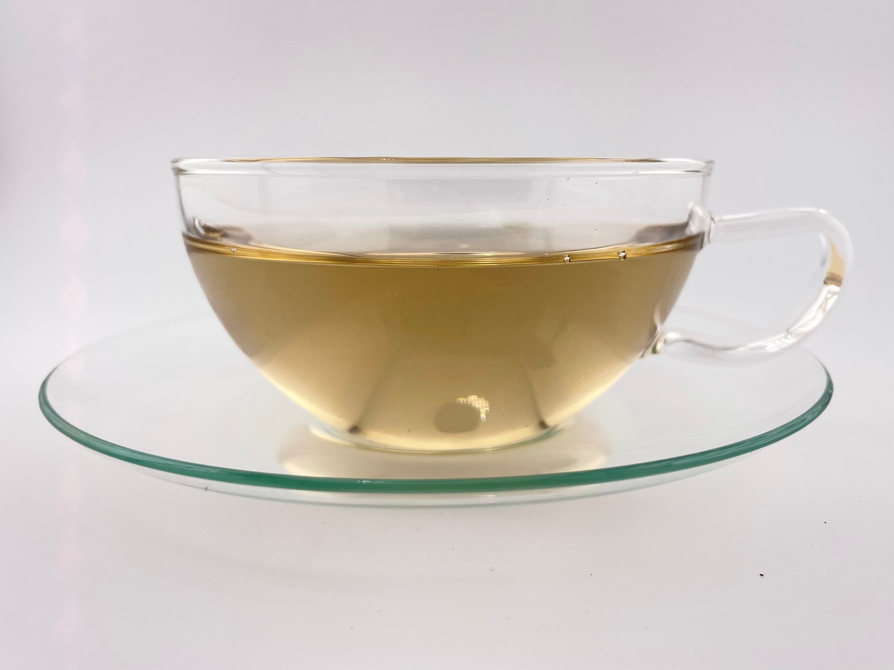 Clear glass teacup with tea on a white background