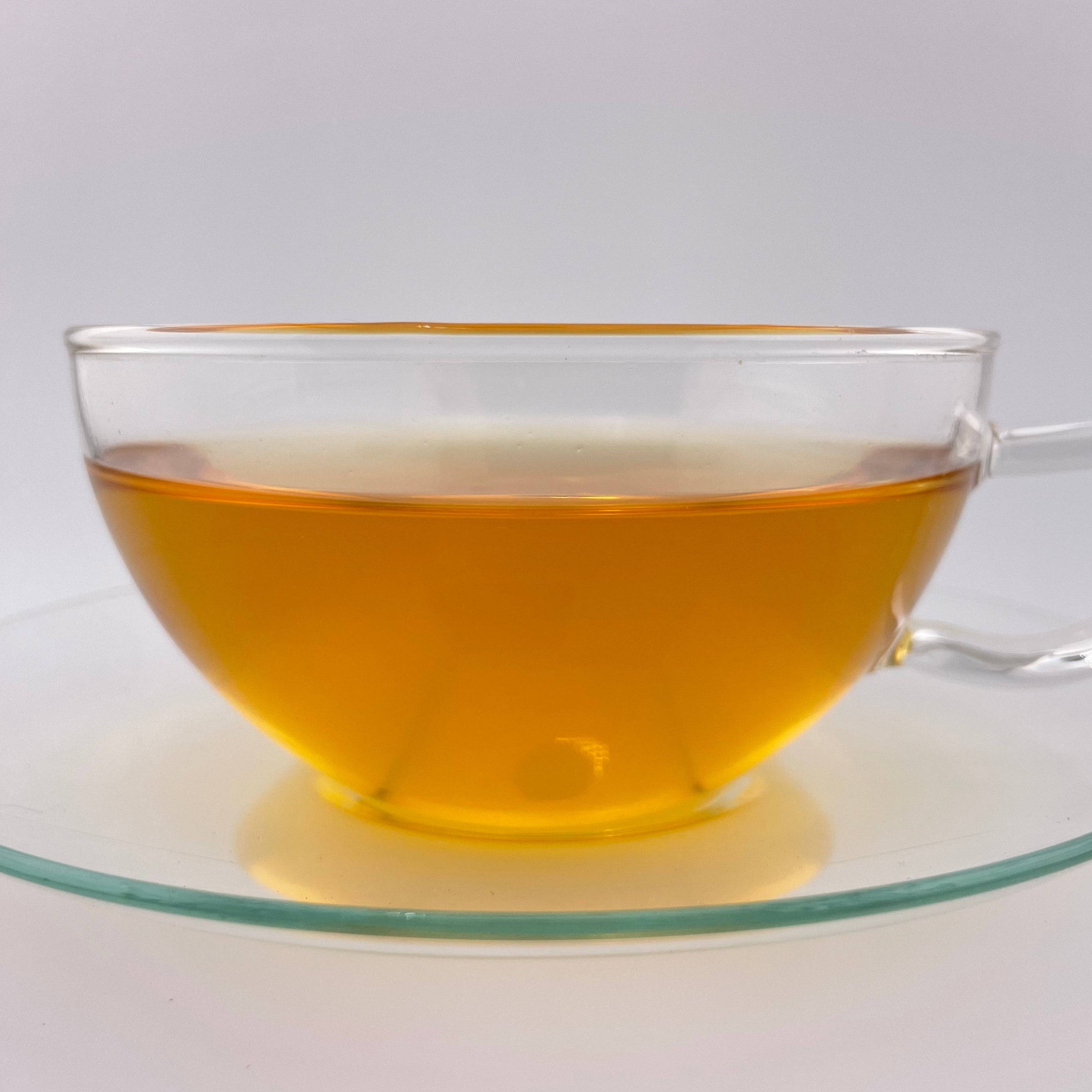 yellow liquor in clear glass teacup