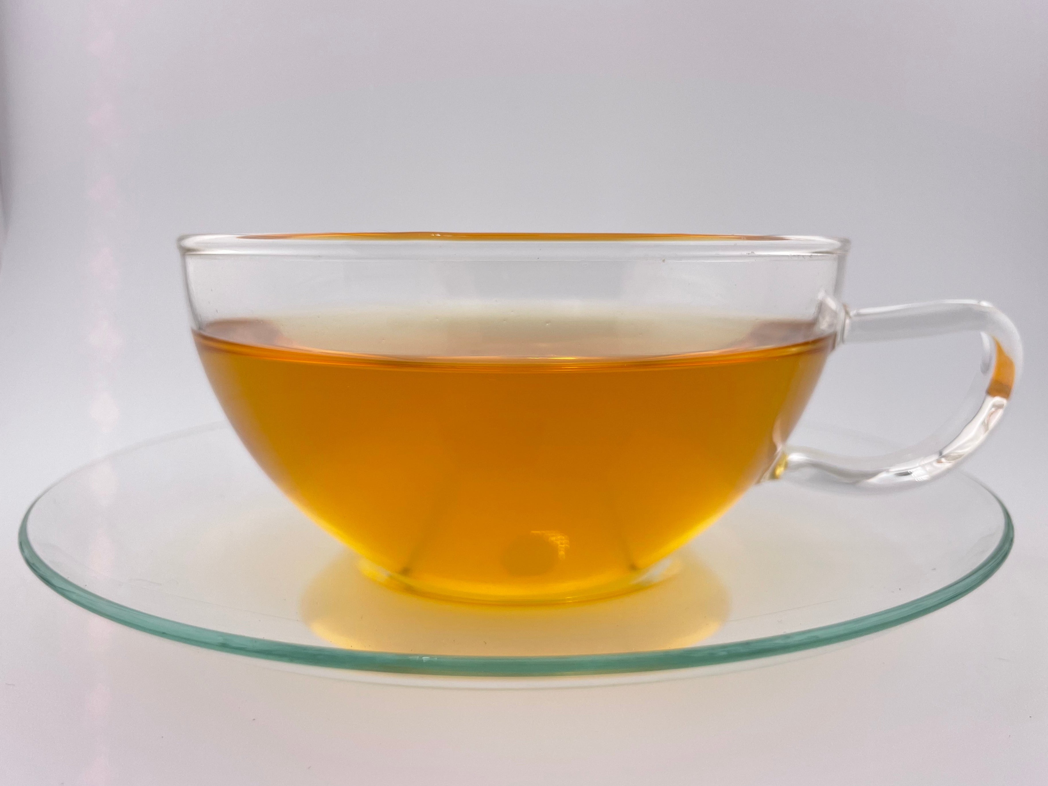 yellow liquor in clear glass teacup