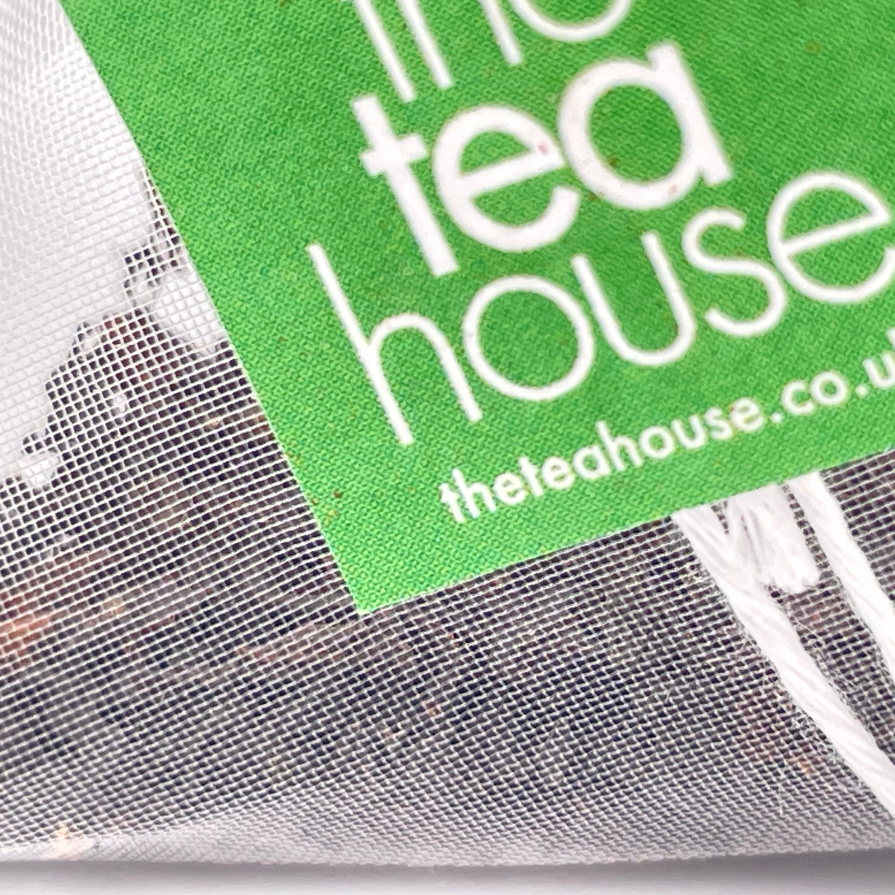Teabag with loose leaf tea and tag "theteahouse"