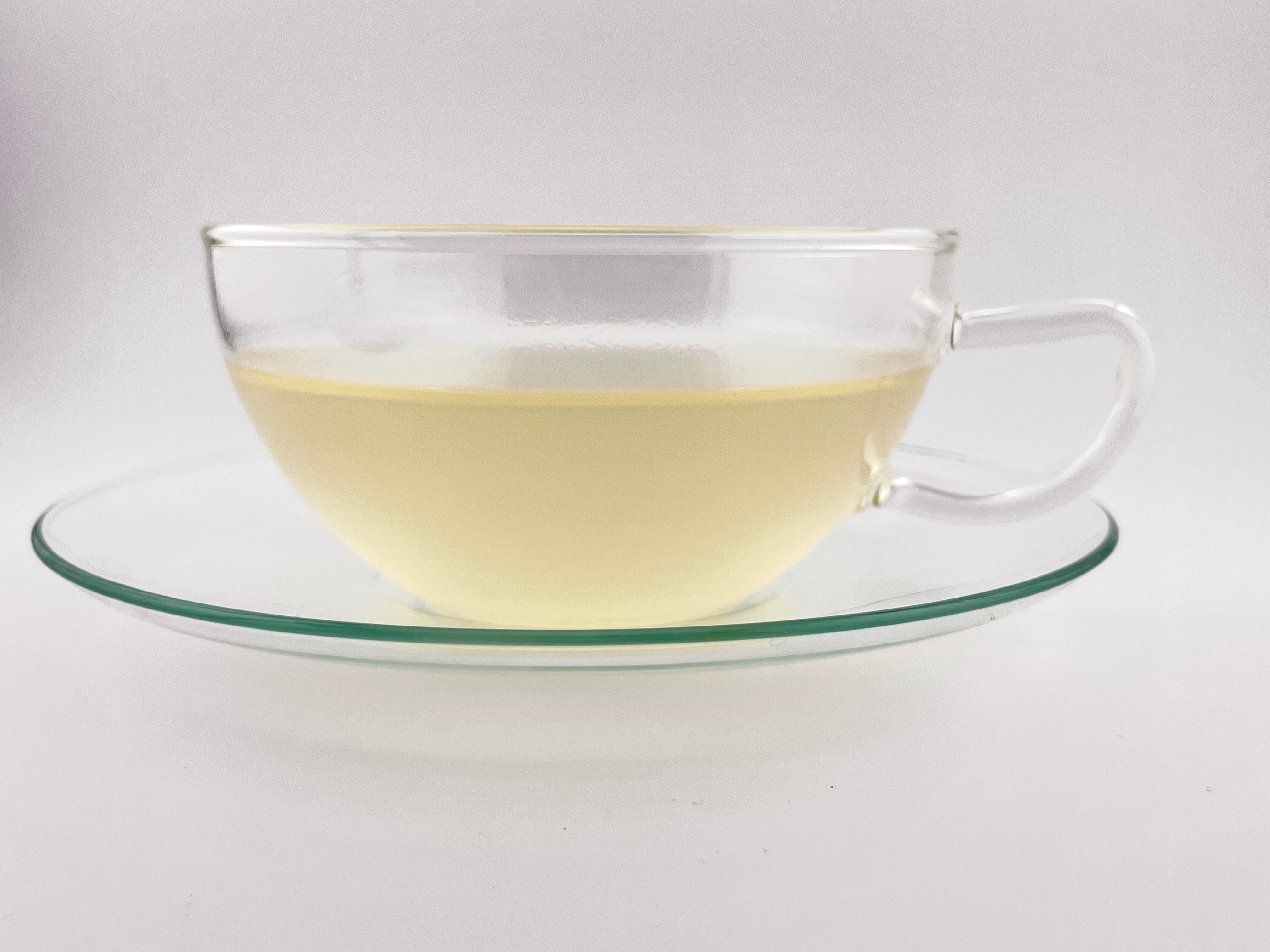 Light yellow liquor in a tea cup with white background