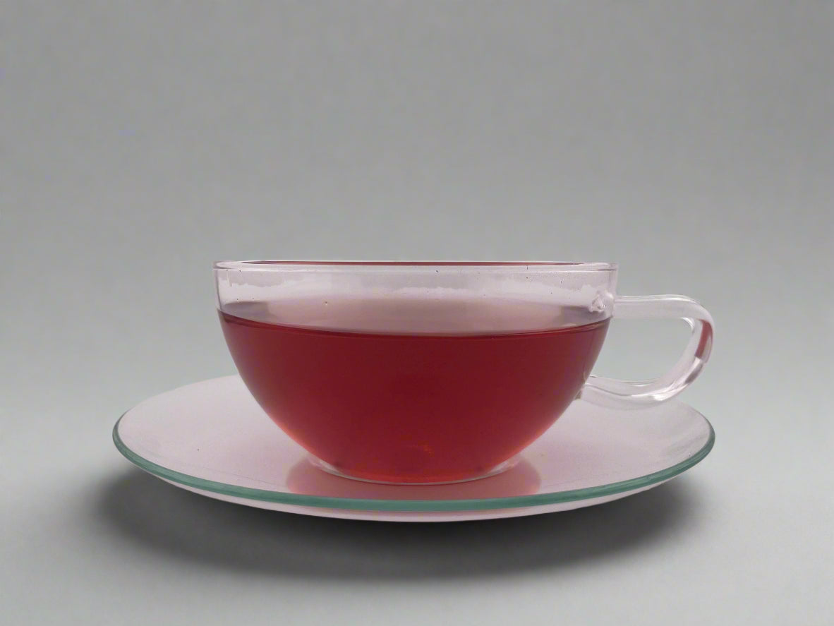 red liquor in clear teacup on white background